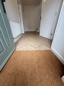 Herringbone LVT flooring with door mat in a new build home by Koti Homes